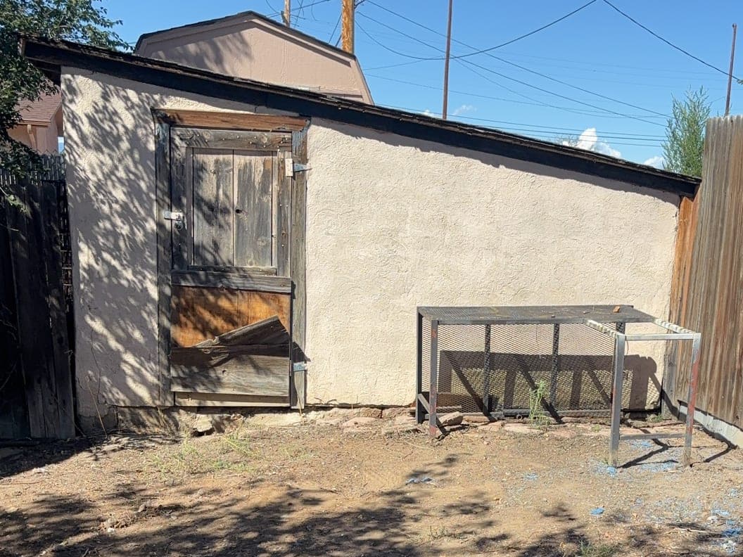 After: the same backyard by the stucco shed, cleared to bare ground
